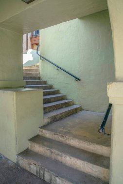 San Antonio Nehri 'nin yanında Texas Nehri' nde duvara monte edilmiş tırabzanları olan beton yıldız taşı. Açık yeşil duvarların arasında L tipi merdiven var..