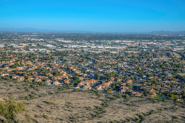 フェニックス アリゾナ州 ピマキャニオントレイルの下の裕福な地区の眺め 正面には山の斜面に住宅街があり 奥には商業ビルが見える — ストック写真