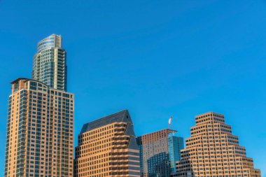 Austin Texas 'taki apartmanlar ve daireler modern mimari tarzın resmedildiği yerler. Güneşli bir günde güzel bir şehir manzarası. Binalar berrak ve parlak mavi gökyüzüne karşı yükseliyor..