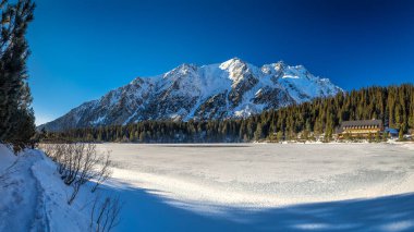 Kış mevsiminde donmuş tarnlı panoramik dağ manzarası. Popradske Pleso Gölü, High Tatras Ulusal Parkı, Slovakya, Avrupa.