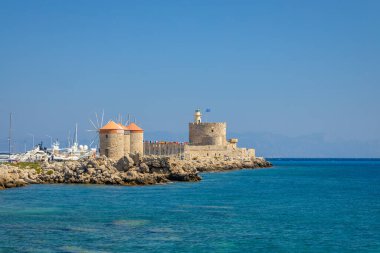 Windmills of Mandraki harbour and Saint Nicholas Fortress in Rhodes town, Greece, Europe.