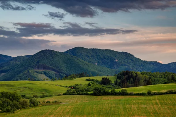 夕暮れ時に劇的な空と春の田園風景 スロバキアの小さなファトラ山脈の丘の中腹にあるメドウズ ヨーロッパ — ストック写真
