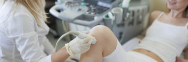 Diz eklem ultrason doktoru kadın hastayı muayene etti.
