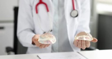 Doktor mamolog elinde silikon implantlar tutuyor. 4K film.