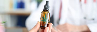 Doktor randevusundaki hastanın elinde bir şişe marihuana yağı var.