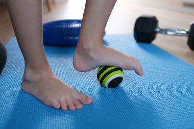 Çocuk ayakları evde küçük bir spor topunun üzerinde.