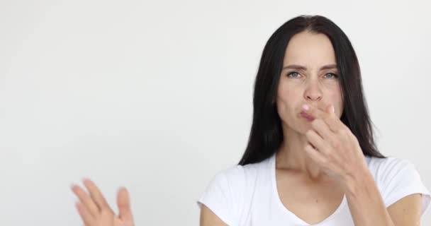 Молодая женщина, прикрывающая нос и машущая рукой 4К фильм — стоковое видео