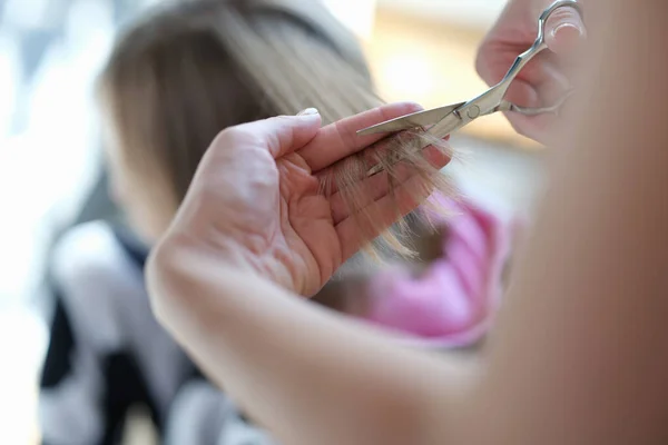 Maître coiffeur coupe pointes fourchues de cheveux avec ciseaux gros plan — Photo