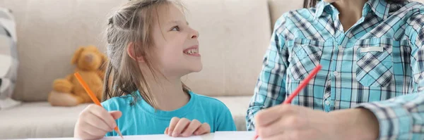 Gelukkig mam en dochter tekenen met potloden op papier — Stockfoto