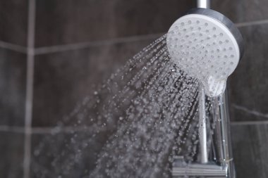 Krom kaplamalı duş karıştırıcıdan akan sular yakın plan