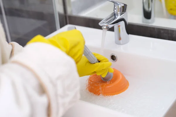 A sárga kesztyűs személy a mosdókagylót takarítja az elzáródás közeléből. — Stock Fotó