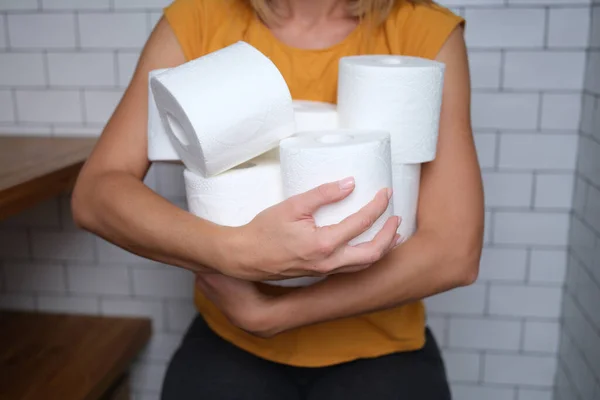 Kvinna som håller många rullar toalettpapper i badrum närbild — Stockfoto