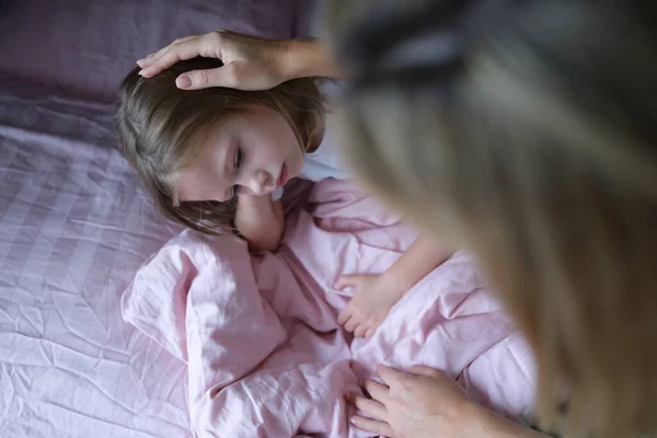 Mamma mette ragazza triste sulla testa prima di andare a letto. — Foto Stock