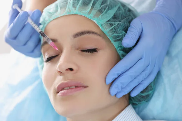 Врач-косметолог делает инъекции в носовую область пациентки в клинике — стоковое фото