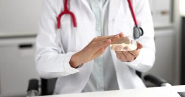 Doktor mamolog göğüs büyütme prosedürü için silikon implantı tutuyor. 4K film.