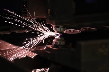 Endüstriyel lazer, düz metal levha ve kıvılcımlar üreten üretim teknolojisini kesiyor.