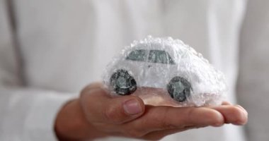 Kadın oyuncak arabayı plastik ambalajlı 4K filmle tutuyor.
