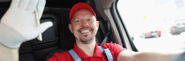 Sorrindo mensageiro masculino motorista acena a mão enquanto dirige — Fotografia de Stock