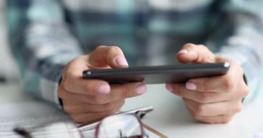 Siyah akıllı telefon tutan ve 4K film yazan kadın eller.