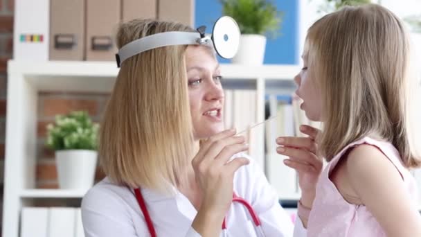 ENT woman conducts physical examination of little girl throat in clinic 4k movie — Stock Video