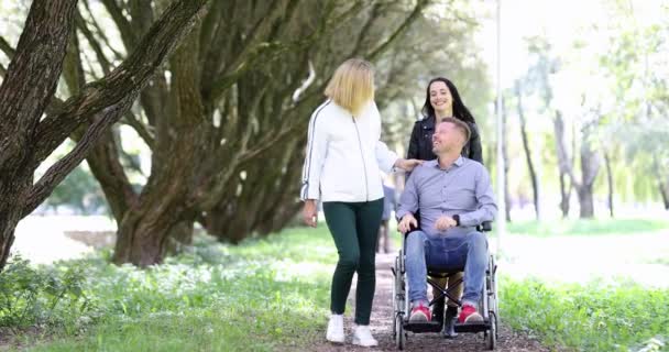 若い女性が公園を歩くと車椅子の男4k映画 — ストック動画