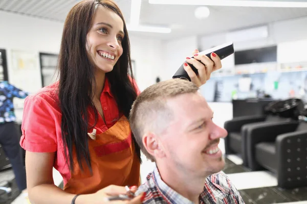 Penata rambut wanita di salon membuat gaya rambut pria. — Stok Foto