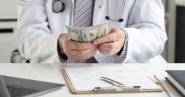 Doktor ofisinde oturuyor ve $4K film sayıyor.