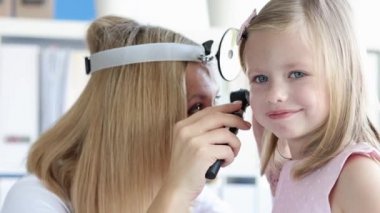 Otolaryngologist küçük kız kulağının 4K filminde fizik muayenesi yapıyor.