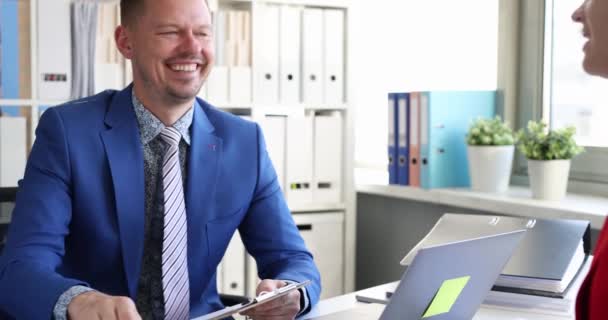 Lächelnde Geschäftsleute beim Händedruck, während sie im Büro am Tisch sitzen 4k-Film — Stockvideo