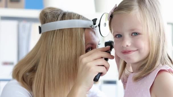 Отоларинголог проводить фізичне обстеження маленької дівчинки на вухо фільму 4k — стокове відео