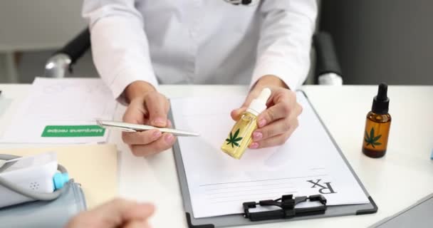 Doutor dá óleo de maconha paciente em frasco para paciente na clínica filme 4k — Vídeo de Stock