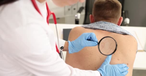 Dermatólogo examina marca de nacimiento del paciente con lupa en la clínica película 4k — Vídeos de Stock