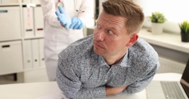 Médico proctólogo lleva a cabo examen médico de joven paciente masculino película 4k — Vídeos de Stock