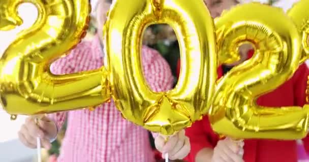 Joyful happy women hold numbers 2022 against background of New Year tree 4k movie — Stock Video