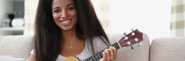 Young african american woman playing musical instrument ukulele — Stock Photo, Image