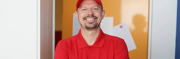 Retrato de mensajero masculino sonriente en uniforme rojo — Foto de Stock