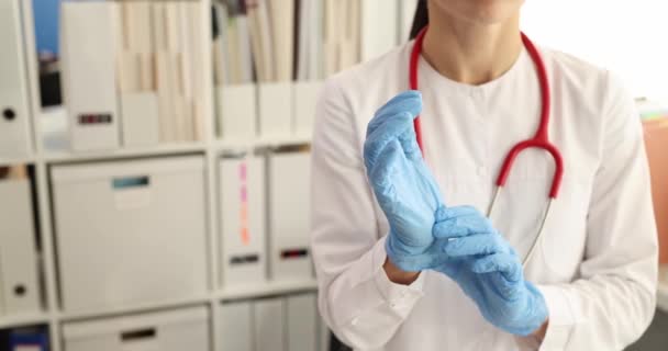 Vrouwelijke arts het aantrekken van steriele medische rubber handschoenen in kliniek 4k film — Stockvideo