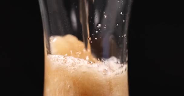 Schuimige drank wordt gegoten in transparante glazen beker 4k film — Stockvideo