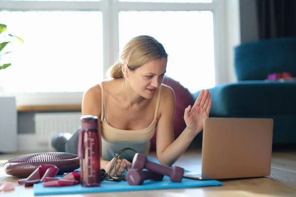 Jovem fazendo exercícios esportivos com um treinador online — Fotografia de Stock