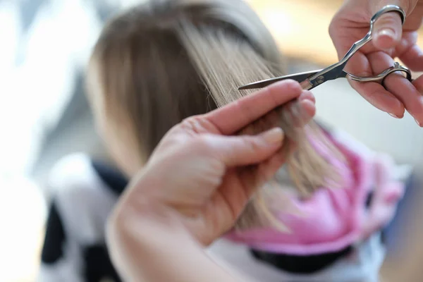 Le mani femminili tagliano i capelli di una donna con le forbici — Foto Stock