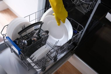 Tabakları bulaşık makinesine, tabağa, çatala, kaşığa yüklüyorum.