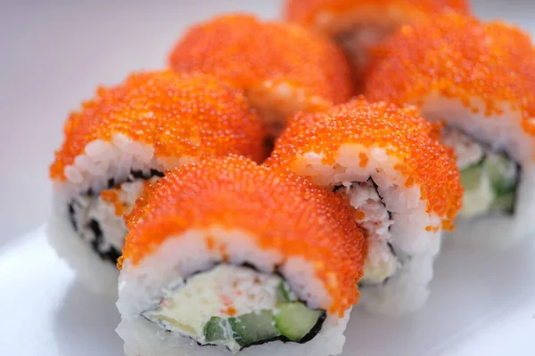 Яркие вкусные суши с икрой на белой поверхности — стоковое фото