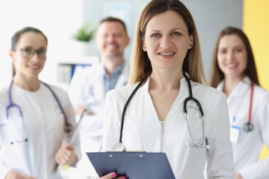 Meslektaşlarının arka planında başarılı kadın doktor portresi
