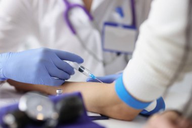 Hemşire klinikteki dirsek damarına damar içi enjeksiyonu yapıyor.