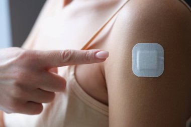Coronavirus aşısı enjeksiyonu altında parmak sıvasını gösteren bir kadın.