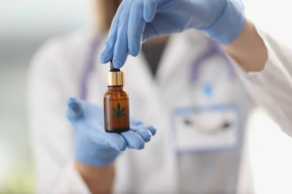 Forskare kemist i skyddshandskar håller hampa olja i burk närbild — Stockfoto