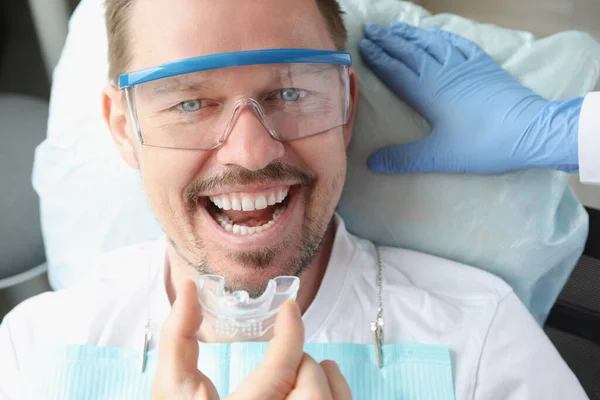 Dokter gigi memasukkan plastik penjaga malam ke manusia di kantor gigi — Stok Foto