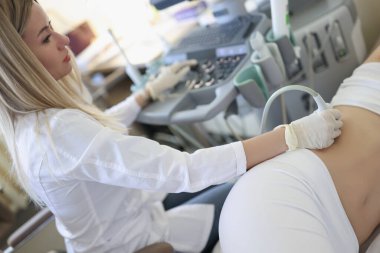 Kadın doktor klinikte ultrason muayenesi yapıyor.