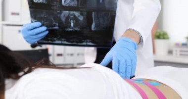 Doktor, hastanın röntgen filmiyle fiziksel muayenesini yürütüyor.