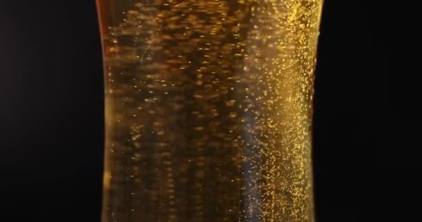 Gelbe transparente Flüssigkeit mit Blasen und Schaum im Glaskelch 4k Film — Stockvideo